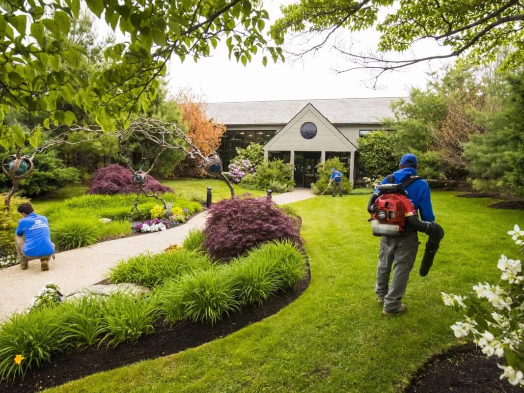Landscaping crew maintaining a manicured garden and lawn on a property in Loudoun County